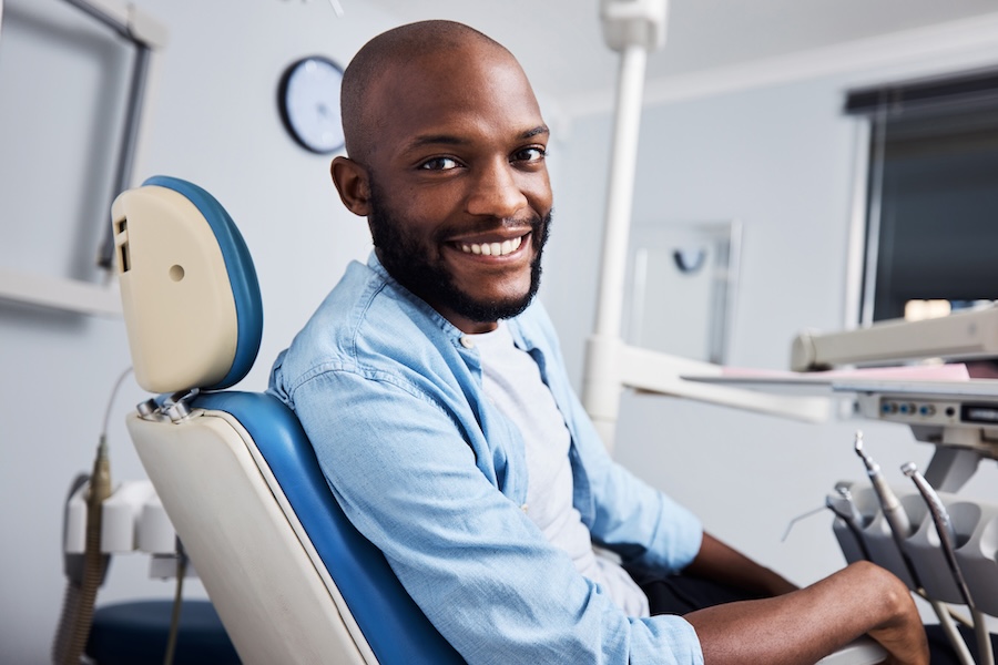 Black man in dental chair seeking restorative dentistry treatment